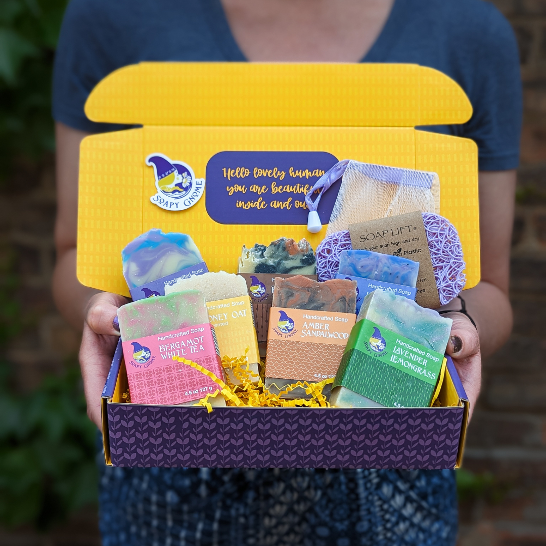 photo of person holding a box of assorted handcrafted soaps and soap savers.